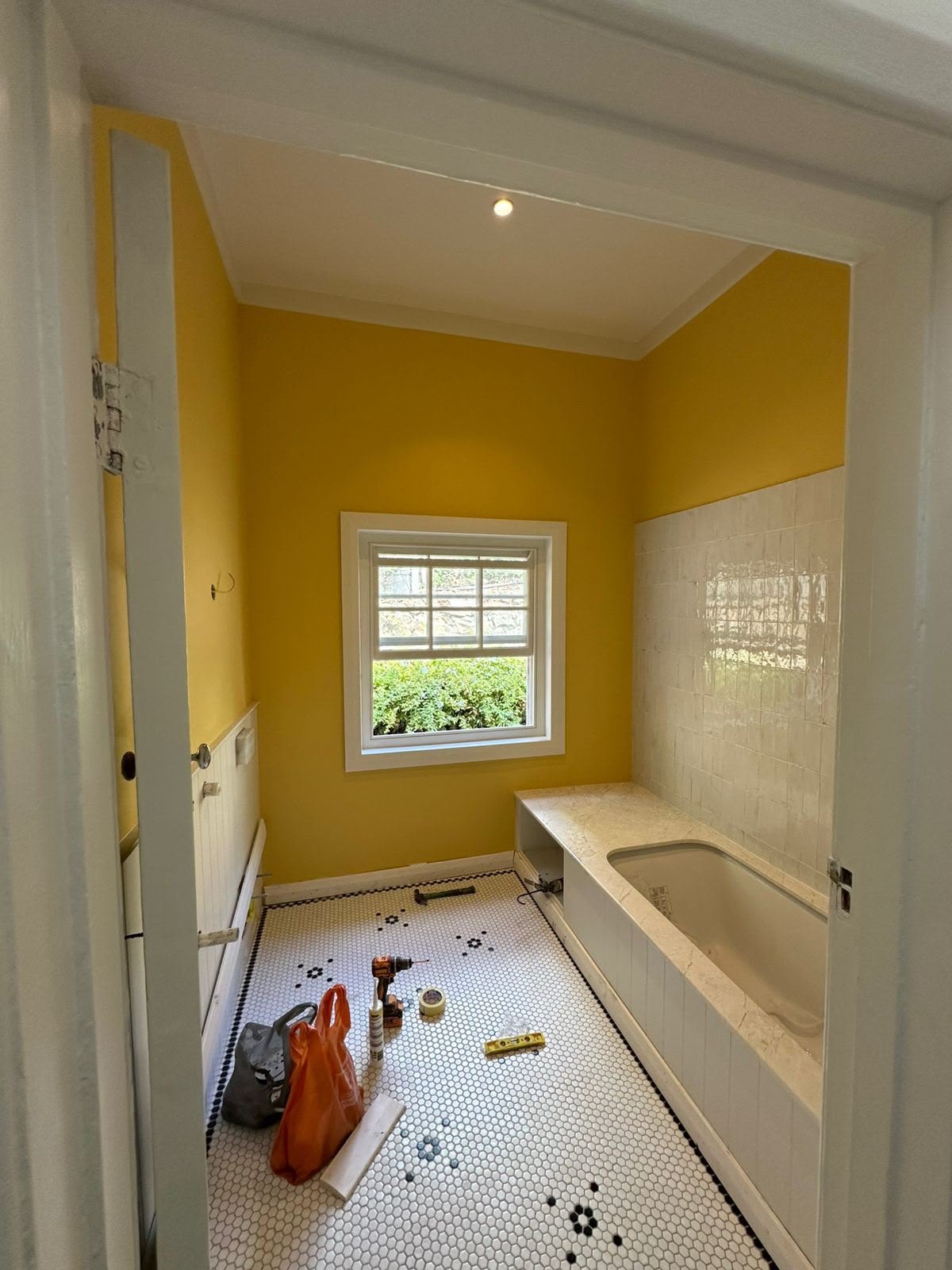 Yellow bathroom mid-renovation at Roseberry Avenue